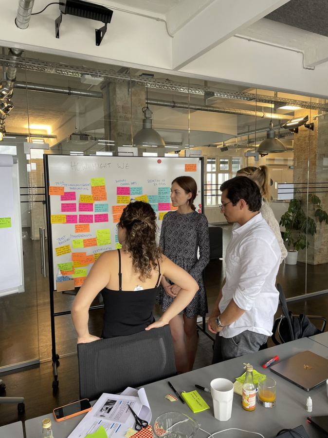 Sprint team clustering How Might We statements on a whiteboard